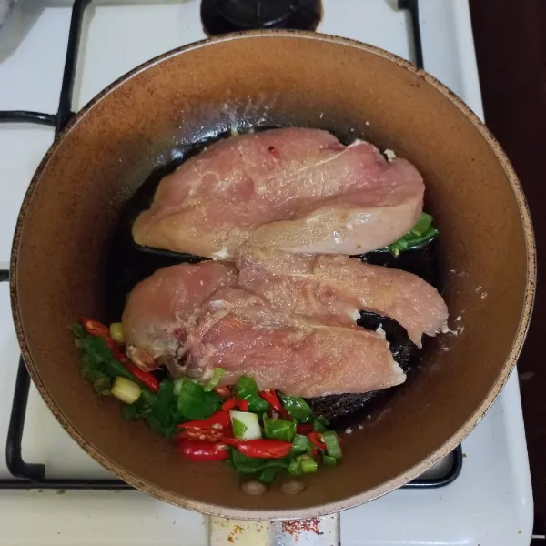 Tata potongan dada ayam di atas teflon.