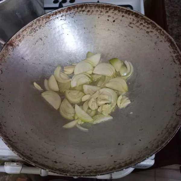 Tumis irisan bawang bombay dan bawang putih hingga harum