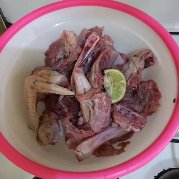 Lumuri potongan ayam kampung dengan jeruk lemin, aduk rata.