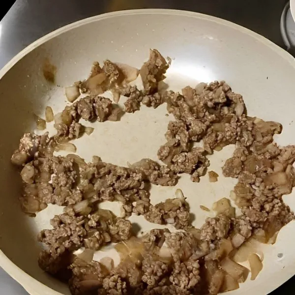 Panaskan wajan dengan sedikit minyak, lalu tumis 200 gr daging sapi cincang dan 50 gr bawang bombay hingga matang. Tambahkan 1/4 sdt garam, aduk rata, lalu angkat dan sisihkan