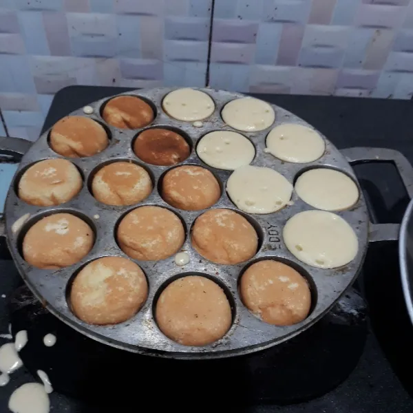 Balik bolu jika bagian bawahnya sudah matang. Masak kembali hingga kedua sisi matang.
