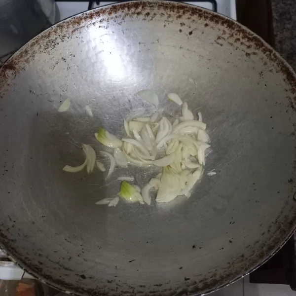 Tumis irisan bawang bombay dan bawang putih hingga harum