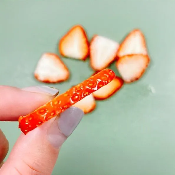 Potong 50 gr strawberry menjadi potongan kecil dan siapkan 3-5 iris strawberry untuk topping