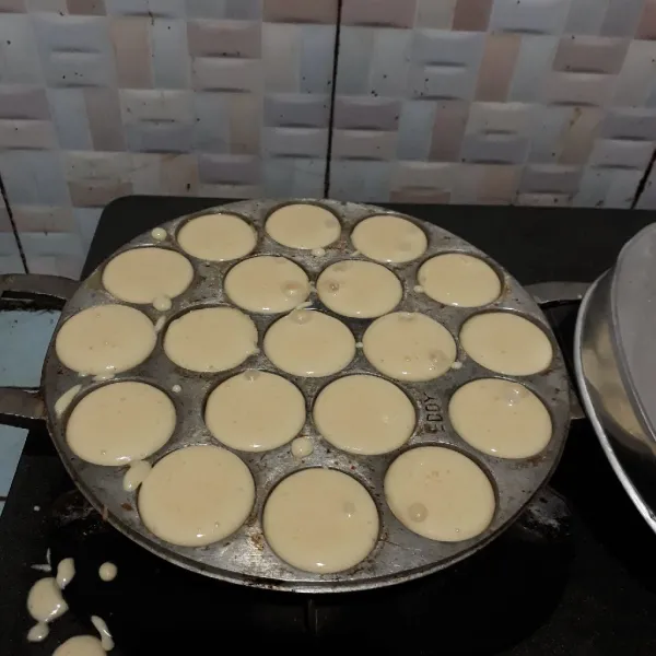 Panaskan cetakan dengan api kecil dan oelsi tipia margarin. Tuang adonan setinggi 3/4 cetakan. Tutup adonan.