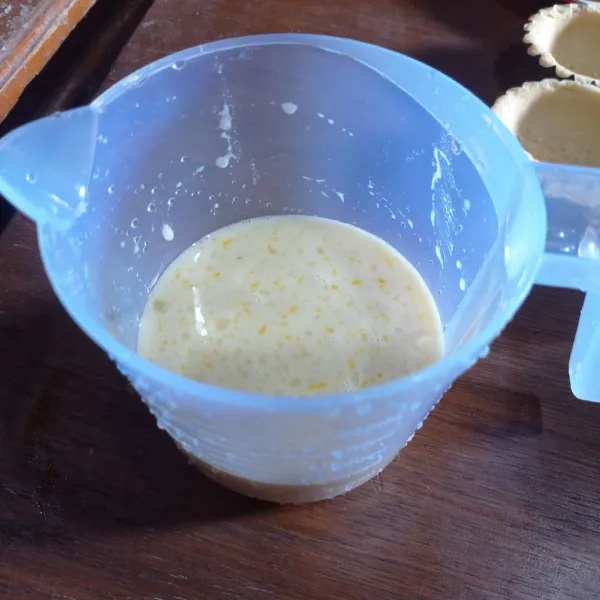 Buat isian susu, campur kental manis, air, gula halus, pasta vanila, telur dan tepung maizena aduk sampai tercampur rata
