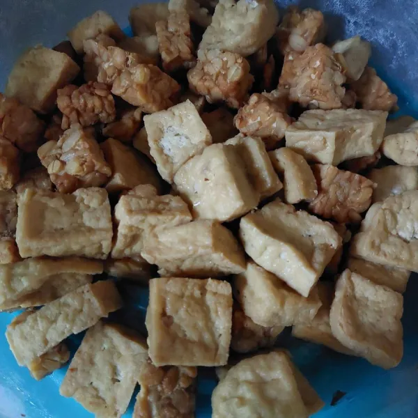 Potong tempe dan tahu, rendam sebentar dengan air yang dibubuhi garam. Kemudian, goreng hingga matang dan berkulit.