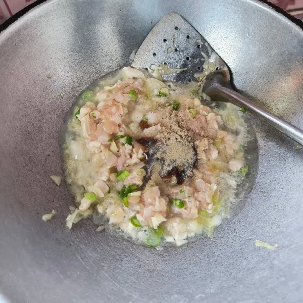 Setelah bumbu matang tambahkan air secukupnya, masukkan daun bawang dan ayam cincang. Bumbui dengan garam, gula, saus tiram dan lada bubuk aduk rata.