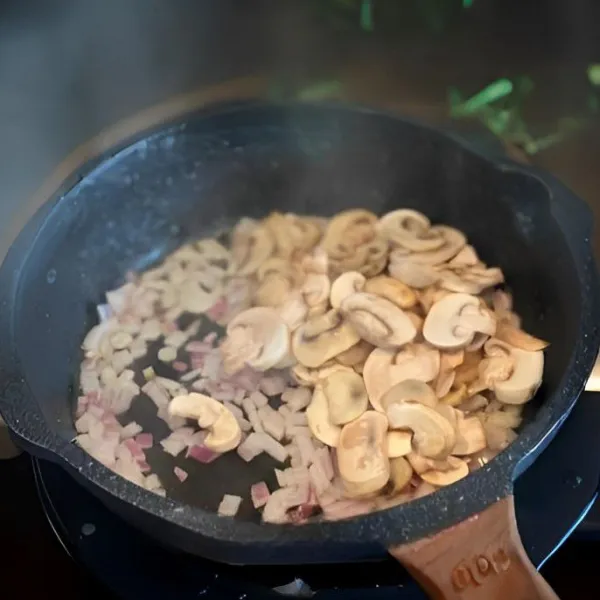 Tambahkan jamur, aduk rata dan masak hingga layu
