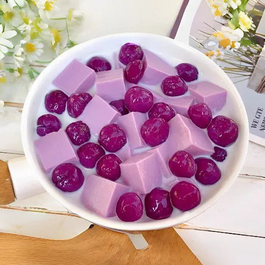 Potong jelly ubi ungu menjadi bentuk kubus kecil. Masukkan dalam mangkuk bersama mutiara ubi ungu, lalu tambahkan susu cair sesuai selera