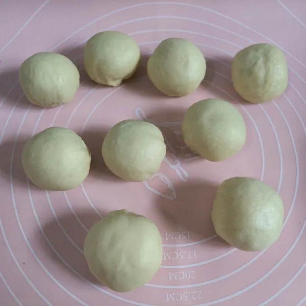 Kempiskan adonan kulit bakpao yang sudah mengembang, kemudian bagi menjadi 8-9 buah lalu bentuk bulat.