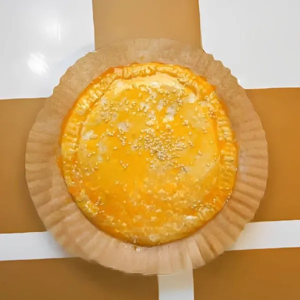 Tutup dengan 1 lembar kulit pastry lainnya, lalu tekan bagian pinggirnya agar tertutup rapat. Olesi permukaan pastry dengan 1 butir kuning telur dan taburi 5 gr biji wijen putih di atasnya