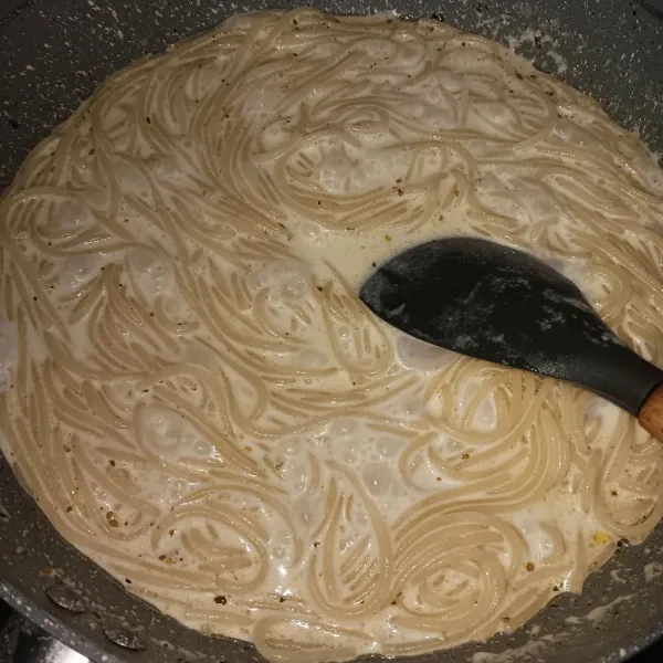 Masukkan spahetti, masak sambil diaduk terus beberapa saat sampai dirasa spaghetti cukup matang dan cairan meresap.