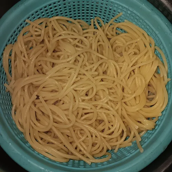 Rebus air sampai mendidih, tambahkan garam dan minyak masak. Masukkan spaghetti masak 6 menit atau setengah kering. Tiriskan. Sisihkan 200 ml air rebusannya.