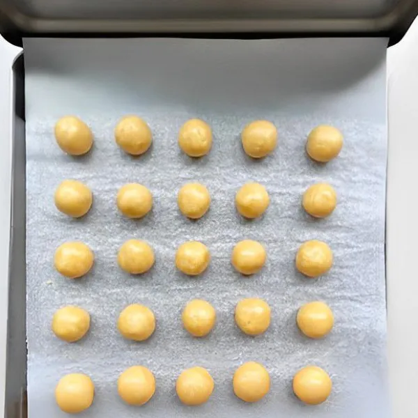 Bentuk adonan menjadi bola-bola kecil masing-masing seberat 10 gr. Tata bola adonan di atas loyang yang sudah dialasi kertas baking