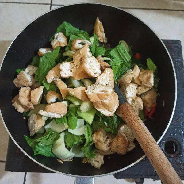 Masukan sawi dan tahu pong, aduk rata