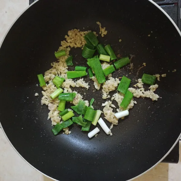 Setelah kecoklatan masukkan daun bawang, masak hingga layu