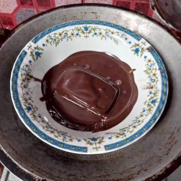 Tim coklat batang diatas wajan berisi air hingga meleleh