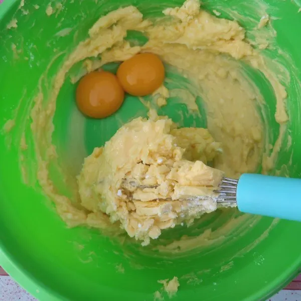 Kemudian tambahkan kuning telur dan vanilla essence, aduk kembali hingga tercampur rata.