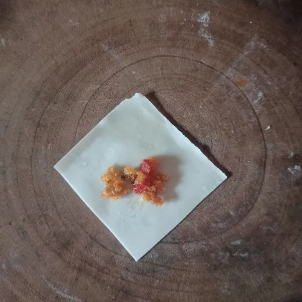Ambil 1 lembar kulit pangsit lalu beri isian abon ayam.