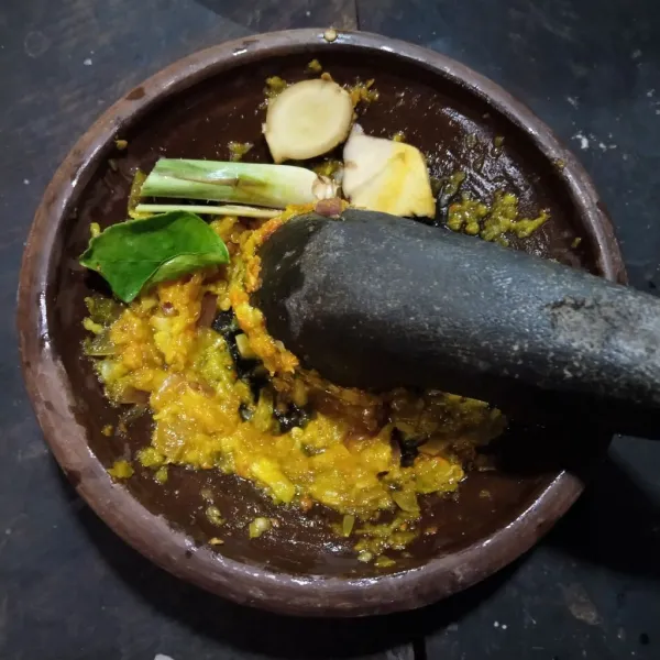 Haluskan cabe, bawang bawangan dan kunyit.