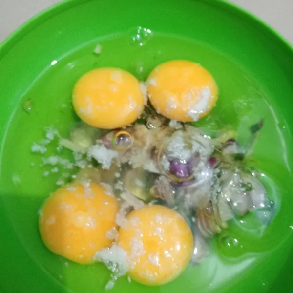 Pecahkan telur dalam wadah. Masukkan irisan bawang merah, daun bawang, garam, dan kaldu ayam. Kocok rata.