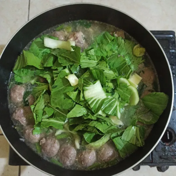Setelah bakso matang masukkan irisan sawi, pakcoy, aduk rata, angkat