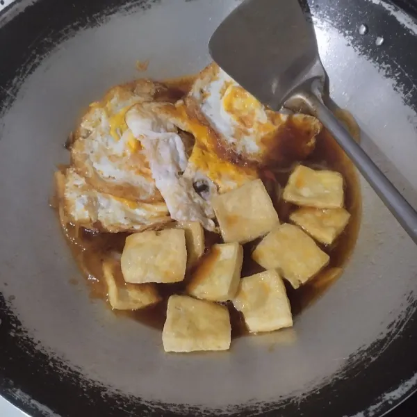 Masukkan telur dan tahu. Aduk kemudian tutup wajan.