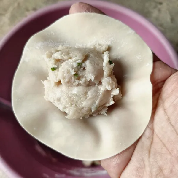Ambil selembar kulit dimsum dan isi dengan sekitar 1 sdm adonan ayam.