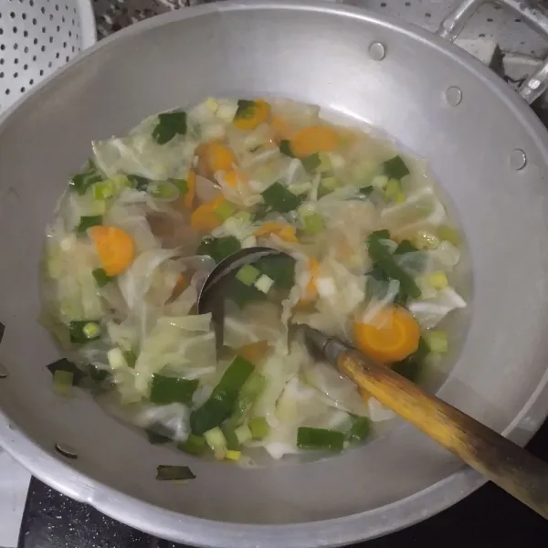 Tambahkan irisan daun bawang. Aduk hingga mendidih serta wortel dan daging empuk. Tes rasa.