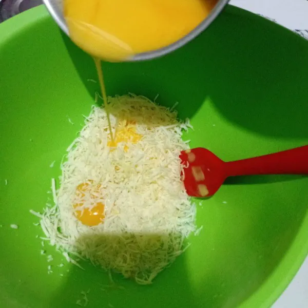 Siapkan wadah, masukkan telur, keju parut, dan margarin yang sudah dilelehkan. Kemudian, aduk hingga rata.