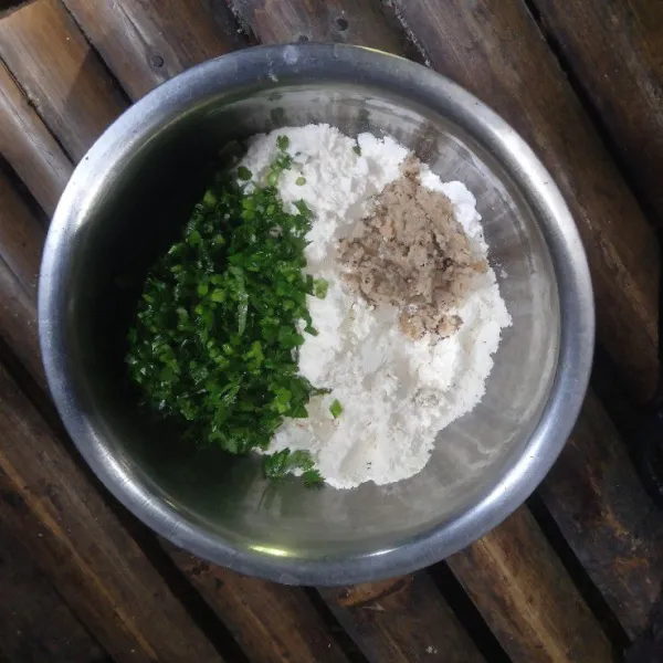 Masukkan tepung terigu, bumbu yang sudah diulek, dan seledri yang sudah diiris ke dalam baskom.
