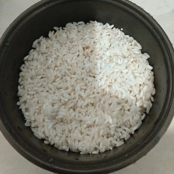 Masukkan beras ketan ke dalam wadah magic com.