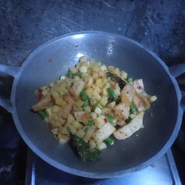 Masukkan irisan kentang, kerupuk krecek, dan buncis. Lalu, aduk hingga merata dan tunggu hingga agak layu.