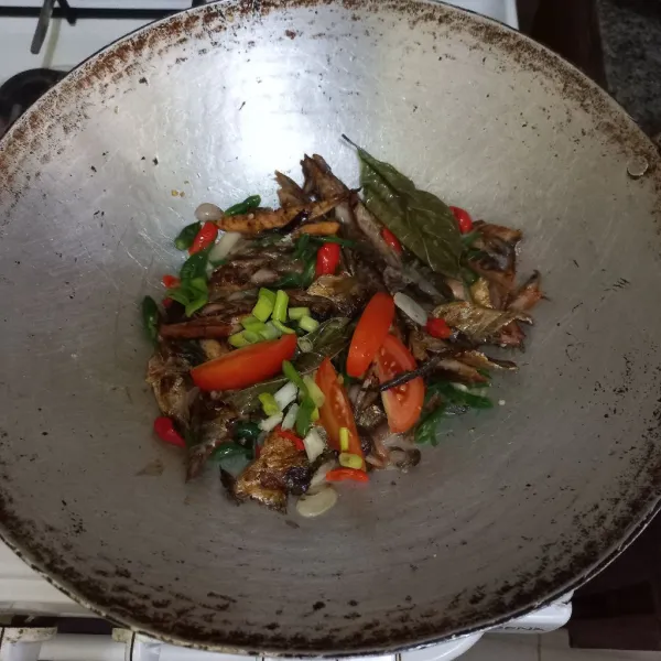 Tambahkan sedikit air, irisan tomat dan bawang dan aduk rata.
