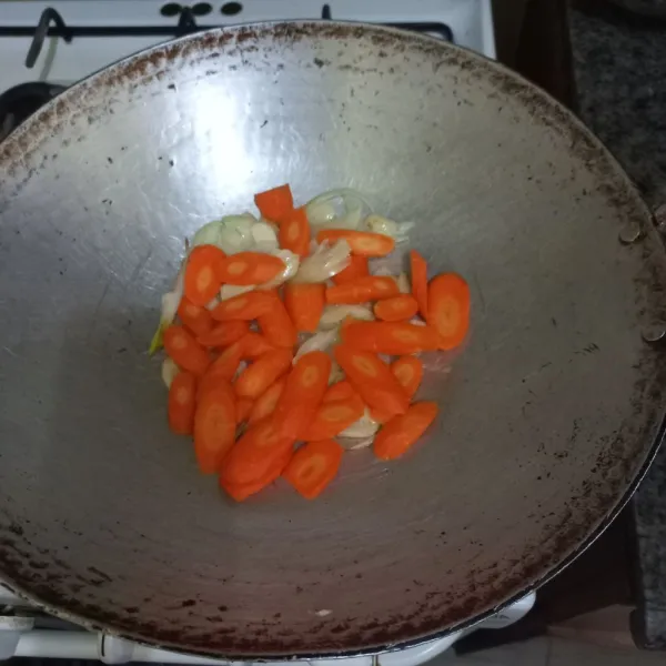 Masukkan irisan wortel, aduk rata.