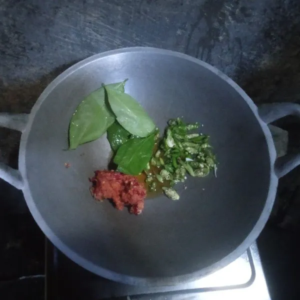 Tumis bumbu yang sudah diulek, irisan cabai rawit hijau, dan daun salam hingga harum.