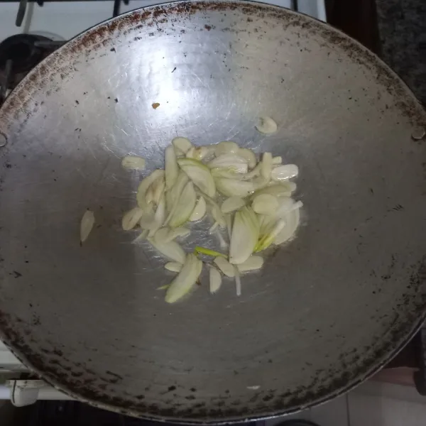 Tumis irisan bawang putih dan bawang bombay hingga harum.