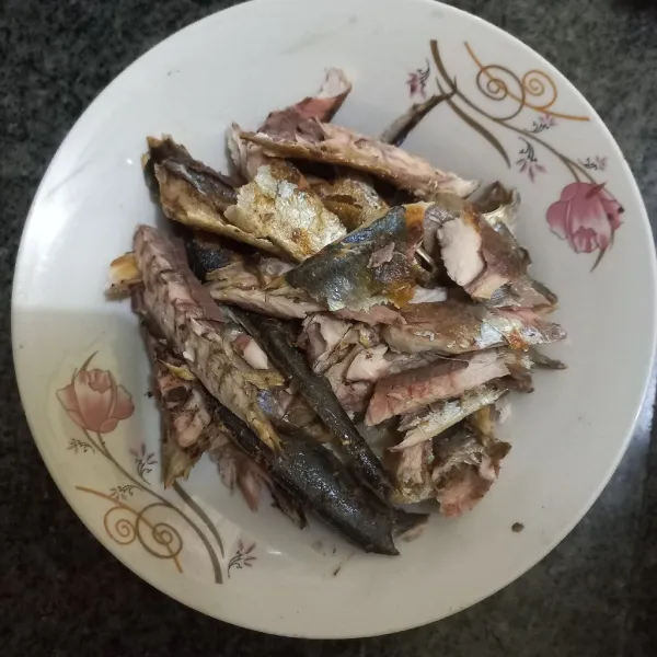 Suwir-suwir besar ikan pindang deles, buang tulang dan durinya.