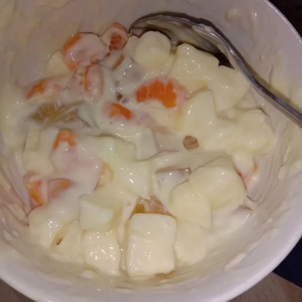 Siapkan wadah, masukkan apel, jeruk, jelly, yogurt, mayonaise, susu kental manis, dan keju. Aduk rata.