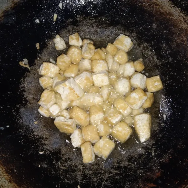 Potong-potong dadu tahu lalu goreng hingga matang kecoklatan