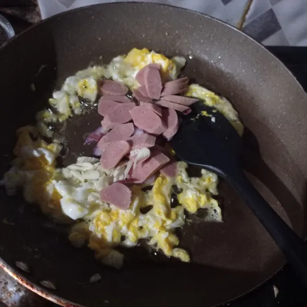 Buat telur orak Arik sampai matang, masukan irisan bawang putih, bawang merah dan sosis aduk rata masak sampai matang