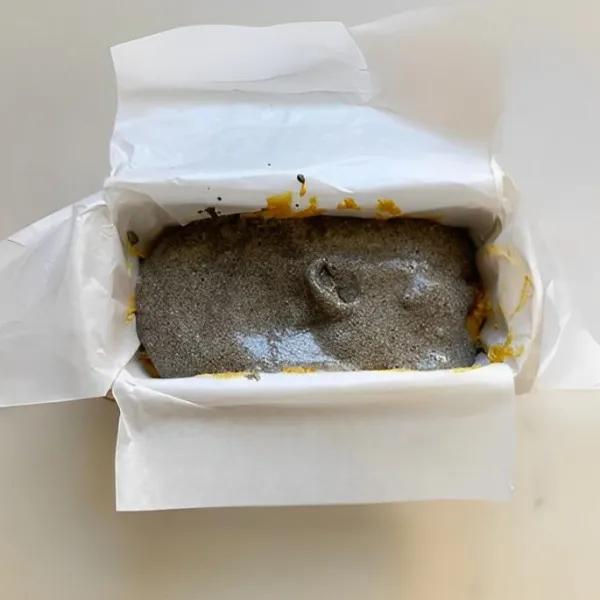 Dalam mangkuk terpisah, campurkan 15 gr bubuk wijen hitam dengan 30 gr susu. Aduk rata, lalu tuang di atas lapisan adonan pertama