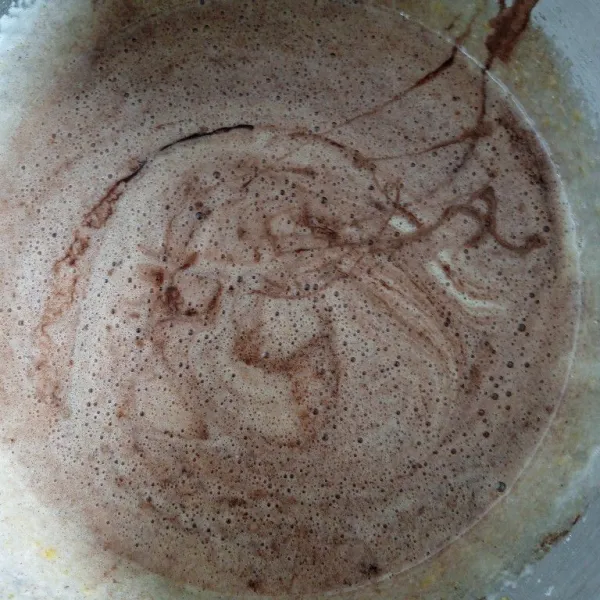 Tambahkan tepung terigu dan coklat bubuk. Aduk rata.