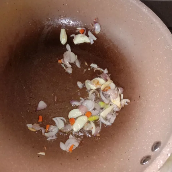 Tumis bawang merah dan bawang putih hingga kecoklatan, lalu masukkan cabe rawit merah.