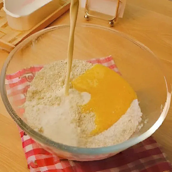 Tambahkan 1 butir telur utuh, 30 ml krim cair, dan 10 gr madu karamel ke dalam campuran tepung, aduk hingga merata. Aduk menggunakan spatula hingga membentuk adonan yang tidak lengket dan kering
