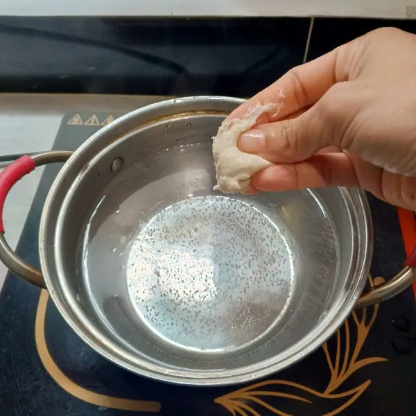 Didihkan air, lalu ambil sedikit adonan dengan tangan seperti mencubit. Lakukan hingga semua bahan selesai.