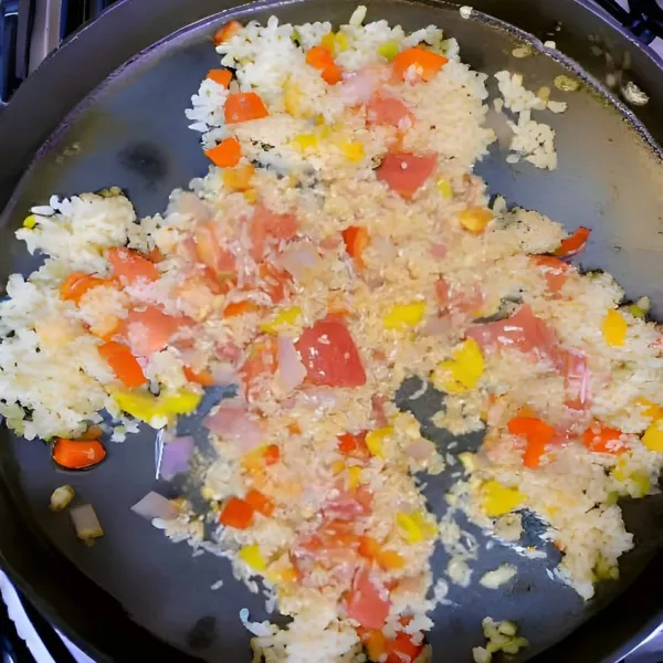 Tambahkan 200 gr nasi putih. Aduk rata dengan bahan tumisan