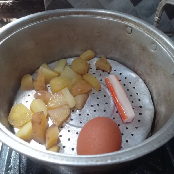 Potong kentang jadi kecil kecil, lalu kukus bersama telur dan crabstik sampai matang