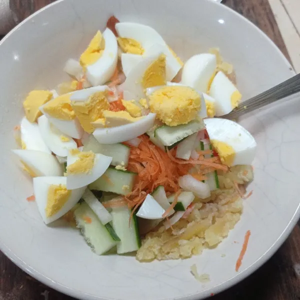 Potong telur, iris timun buang bagian tengahnya, iris juga crabstik dan wortel, masukan ke kentang yang sudah dihaluskan