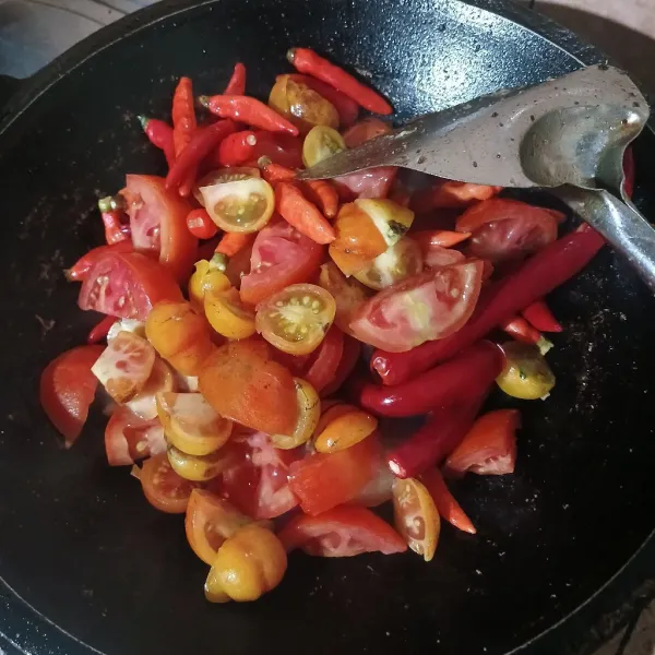 Goreng cabe dan tomat dengan sisa minyak menggoreng teri hingga layu.